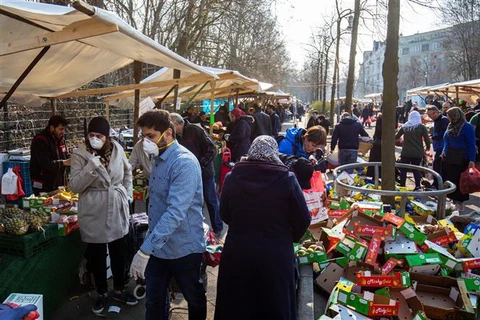 Người dân mua sắm tại một khu chợ ở Berlin, Đức. (Ảnh: AFP/TTXVN)