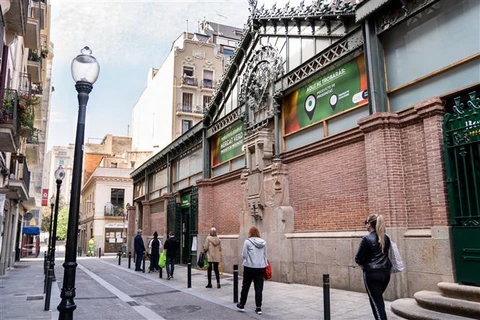 Người dân tuân thủ quy định giãn cách xã hội khi xếp hàng vào một khu chợ ở Barcelona, Tây Ban Nha. (Ảnh: THX/TTXVN)