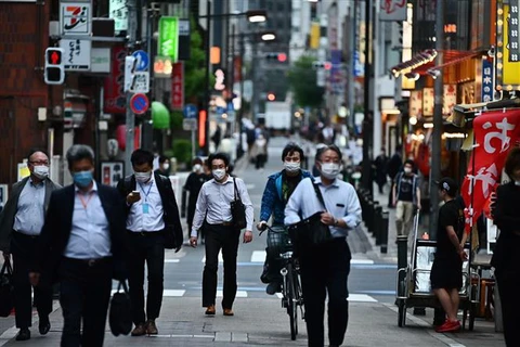Người dân Nhật Bản di chuyển trên một đường phố. (Ảnh: AFP/TTXVN)