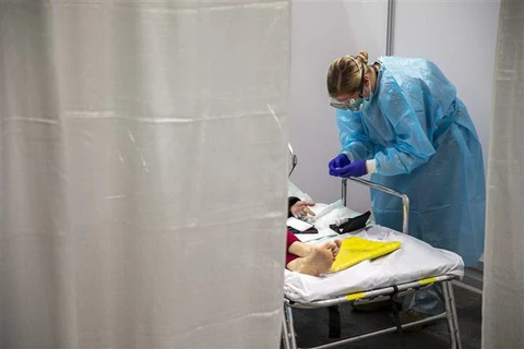 Nhân viên y tế chăm sóc bệnh nhân COVID-19 tại trung tâm y tế ở New York, Mỹ. (Ảnh: AFP/TTXVN)