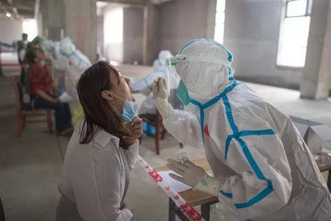 Nhân viên y tế lấy mẫu xét nghiệm COVID-19 cho người dân tại Hồ Bắc, Trung Quốc. (Ảnh: THX/TTXVN)