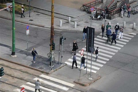Người dân di chuyển trên đường phố tại Milan, Italy. (Ảnh: THX/TTXVN)