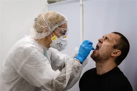 Nhân viên y tế lấy mẫu xét nghiệm COVID-19 tại Moskva, Nga. (Ảnh: AFP/TTXVN)