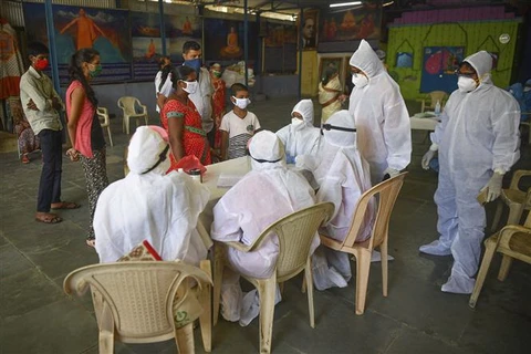 Nhân viên y tế tư vấn cho người dân về cách phòng tránh dịch COVID-19 tại Mumbai, Ấn Độ. (Ảnh: AFP/TTXVN)