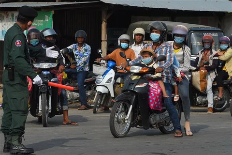 Người dân đeo khẩu trang phòng lây nhiễm COVID-19 tại Campuchia. Ảnh: AFP/TTXVN)