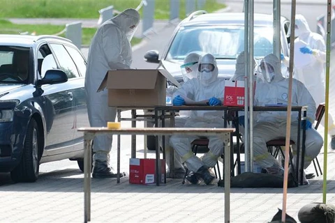 Nhân viên y tế làm việc tại một điểm xét nghiệm COVID-19 ở Laziska Gorne, Ba Lan. (Ảnh: PAP/TTXVN)