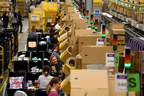 Nhân viên đóng gói hàng hóa cho khách hàng tại trung tâm dịch vụ của Amazon. (Ảnh: AFP/TTXVN)