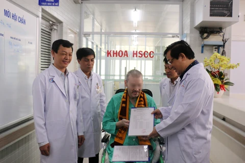 Lãnh đạo Bộ Y tế trao giấy chứng nhận xuất viện và chứng nhận âm tính với virus SARS-CoV-2 cho bệnh nhân 91. (Ảnh: TTXVN phát)