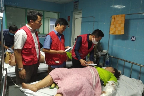 Phó Chủ tịch, Tổng Thư ký Trung ương Hội Chữ thập Đỏ Việt Nam Nguyễn Hải Anh (người đeo khẩu trang trắng) thăm hỏi và động viên các nạn nhân. (Ảnh: Minh Huệ/TTXVN)