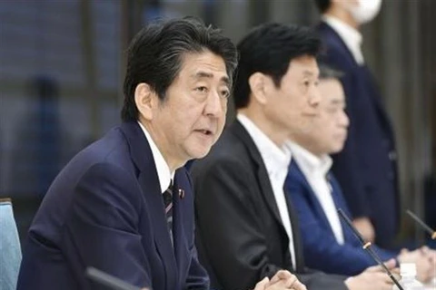 Thủ tướng Nhật Bản Shinzo Abe (trái) tại cuộc họp nội các ở Tokyo, Nhật Bản, ngày 30/7/2020. (Ảnh: Kyodo/TTXVN)