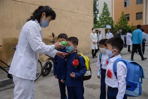 Đo thân nhiệt phòng lây nhiễm dịch COVID-19 tại một trường học ở Bình Nhưỡng, Triều Tiên. (Ảnh: AFP/TTXVN)