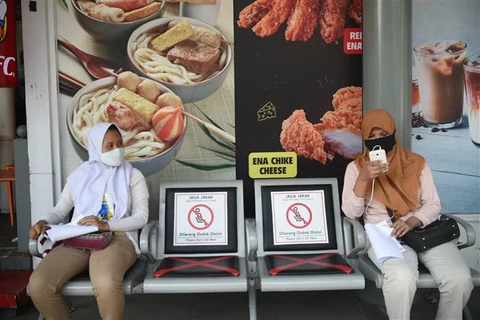  Người dân đeo khẩu trang và thực hiện giãn cách xã hội phòng lây nhiễm COVID-19 tại Jakarta, Indonesia. (Ảnh: THX/TTXVN)
