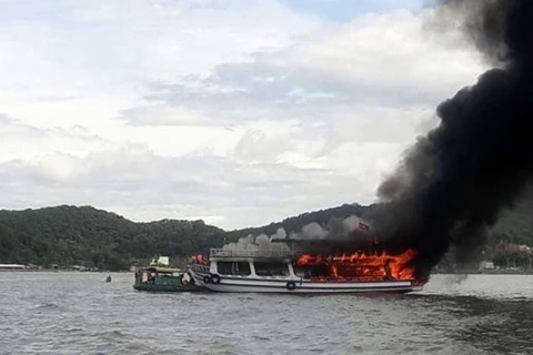 Tàu đưa khách du lịch đi câu cá trên biển bị bốc cháy. (Ảnh: TTXVN phát)