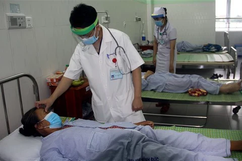 Bác sỹ đang thăm khám cho bệnh nhân bị ngộ độc thực phẩm sau khi sử dụng pate Minh Chay. (Ảnh: Trịnh Bang Nhiệm/TTXVN)