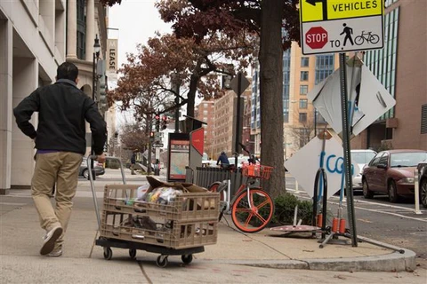 Một nhân viên phân phát thực phẩm trên một đường phố ở Washington, DC, Mỹ. (Ảnh: AFP/TTXVN)