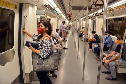 Người dân đeo khẩu trang và thực hiện giãn cách xã hội phòng lây nhiễm COVID-19 khi đi tàu điện ngầm ở New Delhi, Ấn Độ. (Ảnh: THX/TTXVN)