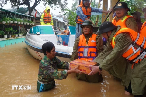 Lực lượng công an tỉnh Thừa Thiên-Huế trao tặng mì tôm cho các gia đình vùng trũng. (Ảnh: TTXVN phát)