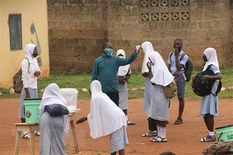 Đo thân nhiệt phòng lây nhiễm COVID-19 tại một trường học ở bang Oyo, Nigeria. (Ảnh: AFP/TTXVN)