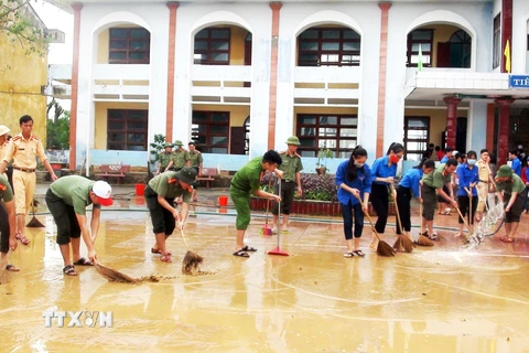 Các đội hình xung kích, tình nguyện của Tuổi trẻ Quảng Bình hăng hái giúp các trường học dọn vệ sinh, khắc phục hậu quả mưa lũ. (Ảnh: Võ Dung/TTXVN)