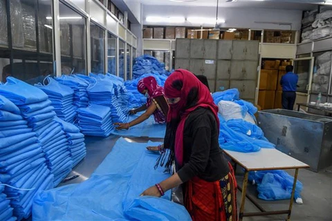 Công nhân làm việc tại cơ sở sản xuất đồ bảo hộ Nikshe ở Ahmedabad, Ấn Độ. (Ảnh: AFP/TTXVN)