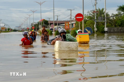 Người dân sơ tán khỏi các khu vực ngập lụt ở Phnom Penh, Campuchia, ngày 17/10/2020. (Ảnh: AFP/TTXVN)