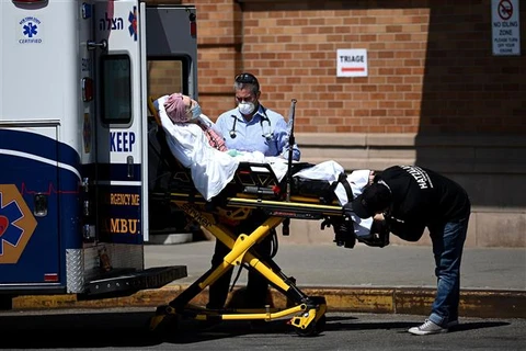 Nhân viên y tế chuyển bệnh nhân COVID-19 tới trung tâm y tế Maimonides ở New York, Mỹ. (Ảnh: AFP/TTXVN)