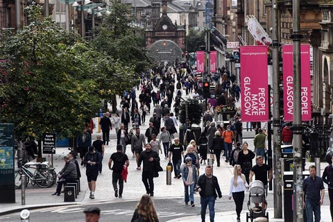Người dân di chuyển trên đường phố tại Glasgow, Anh. (Ảnh: AFP/TTXVN)