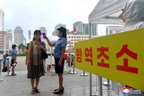 Kiểm tra thân nhiệt hành khách tại một nhà ga ở Bình Nhưỡng, Triều Tiên trong nỗ lực chống dịch COVID-19. (Ảnh: AFP/TTXVN)