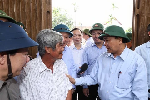 Thủ tướng Nguyễn Xuân Phúc đến thăm hỏi ông Cao Văn Phụng, tại thôn An Hà 1, xã Nghĩa Trung, huyện Tư Nghĩa. (Ảnh: Thống Nhất/TTXVN)