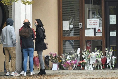 Đặt hoa tại trường trung học ở Conflans Saint-Honorine, sau vụ một giáo viên của trường bị sát hại ngày 17/10/2020. (Ảnh: AFP/TTXVN)