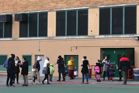 Học sinh tiểu học tới trường trong ngày đầu tiên trường học mở cửa trở lại tại New York, Mỹ. (Ảnh: AFP/TTXVN)
