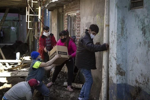 Tình nguyện viên phân phát lương thực cứu trợ do dịch COVID-19 cho người dân tại Buenos Aires, Argentina. (Ảnh: AFP/TTXVN)