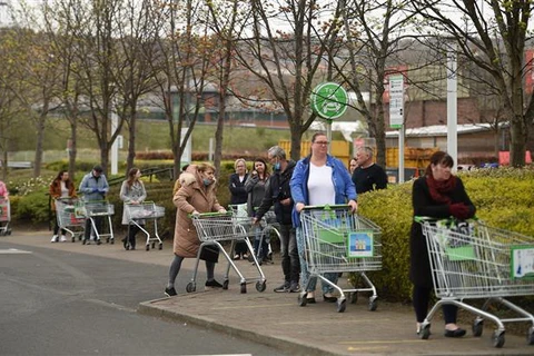 Người dân Anh xếp hàng chờ mua sắm bên ngoài một siêu thị ở Gateshead. (Ảnh: AFP/TTXVN)