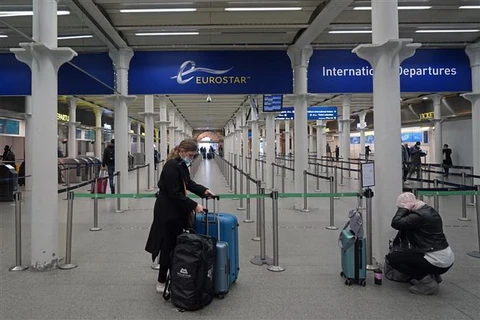 Hành khách đeo khẩu trang phòng lây nhiễm COVID-19 tại sân bay. (Ảnh: AFP/TTXVN)
