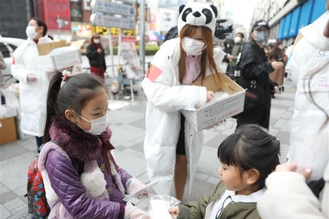Các tình nguyện viên phát khẩu trang miễn phí cho người dân tại Tokyo, Nhật Bản. (Ảnh: THX/TTXVN)