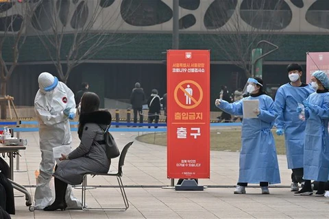Nhân viên y tế lấy mẫu xét nghiệm COVID-19 tại Seoul, Hàn Quốc. (Ảnh: AFP/TTXVN)