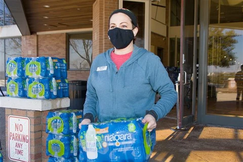 Tình nguyện viên phát nước sạch cho người dân tại ngoại ô thành phố Dallas, bang Texas, Mỹ. (Ảnh: THX/TTXVN)