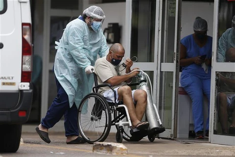 Nhân viên y tế chuyển bệnh nhân nhiễm COVID-19 tới bệnh viện ở Brasilia, Brazil. (Ảnh: THX/TTXVN)