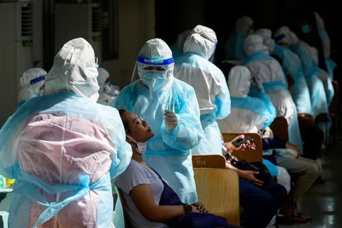 Nhân viên y tế lấy mẫu xét nghiệm COVID-19 tại Bangkok, Thái Lan. (Ảnh: AFP/TTXVN)