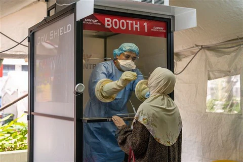 Nhân viên y tế lấy mẫu xét nghiệm COVID-19 cho người dân tại Kuala Lumpur, Malaysia. (Ảnh: THX/TTXVN)