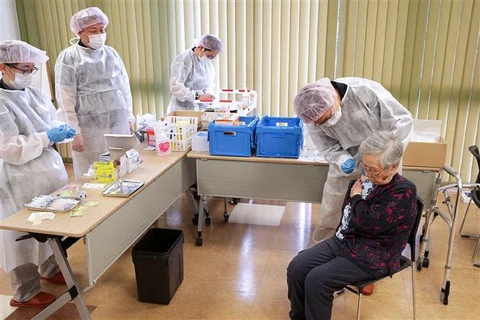 Nhân viên y tế tiêm vaccine ngừa COVID-19 cho người dân tại Tokyo, Nhật Bản. (Ảnh: AFP/TTXVN)