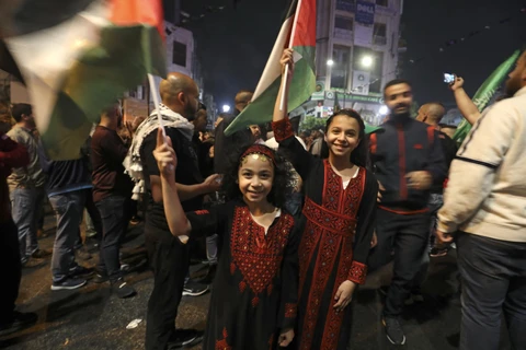 Người dân Palestine tại thành phố Ramallah vui mừng sau khi lệnh ngừng bắn giữa Israel và phong trào Hồi giáo Hamas chính thức có hiệu lực, ngày 21/5/2021. (Ảnh: AFP/TTXVN)