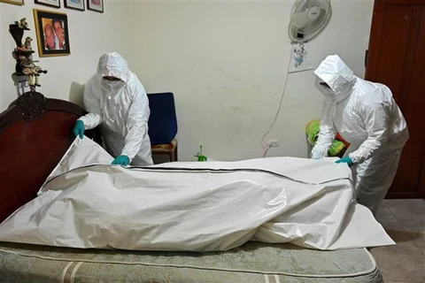 Nhân viên nhà tang lễ chuyển thi thể bệnh nhân tử vong do COVID-19 tại Cali, Colombia. (Ảnh: AFP/TTXVN)