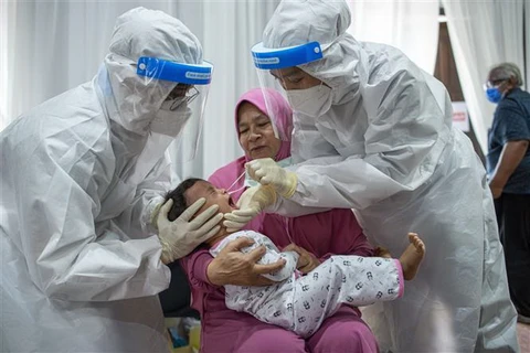 Nhân viên y tế lấy mẫu xét nghiệm COVID-19 cho một em bé tại Rawang, bang Selangor, Malaysia. (Ảnh: THX/TTXVN)