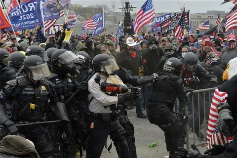 Người biểu tình xung đột với cảnh sát chống bạo động tại Đồi Capitol ở Washington DC., ngày 6/1/2021. (Ảnh: AFP/TTXVN)