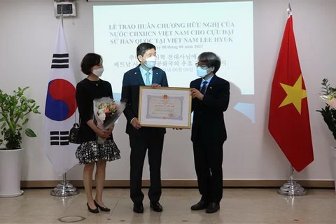 Đại sứ Nguyễn Vũ Tùng (phải) trao Huân chương Hữu nghị cho ông Lee Huyk (trái). (Ảnh: Mạnh Hùng/TTXVN)