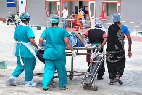 Nhân viên y tế chuyển bệnh nhân nhiễm COVID-19 tới bệnh viện ở Bangalore, Ấn Độ. (Ảnh: THX/TTXVN)