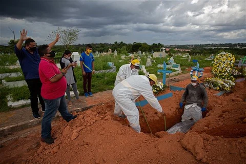 Chôn cất thi thể bệnh nhân COVID-19 tại một nghĩa địa ở bang Amazonas, Brazil. (Ảnh: AFP/TTXVN)