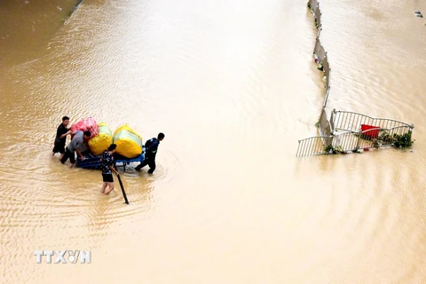 Người dân sơ tán khỏi vùng ngập lụt tại Trịnh Châu, tỉnh Hà Nam, Trung Quốc. (Ảnh: THX/TTXVN)