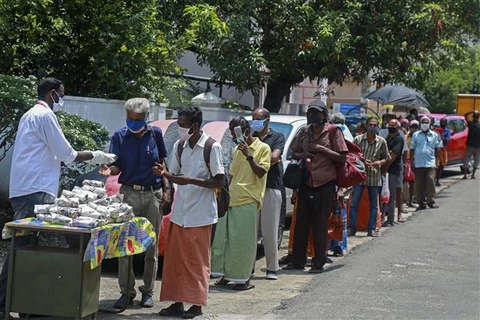 Người dân xếp hàng chờ nhận thực phẩm cứu trợ do dịch COVID-19 tại Kochi, bang Kerala, Ấn Độ. (Ảnh: AFP/TTXVN)